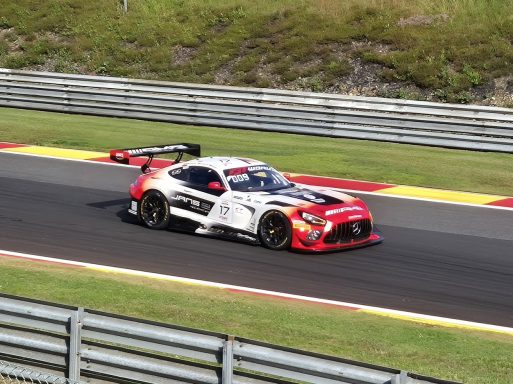 Mercedes AMG GT3 in Spa Schwarzer und roter Rennwagen auf einer Strecke mit grüner Umgebung.