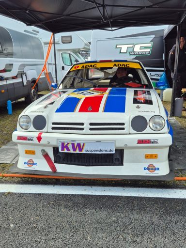 Opel Manta Rennwagen mit auffälliger Lackierung in einer Boxengasse.